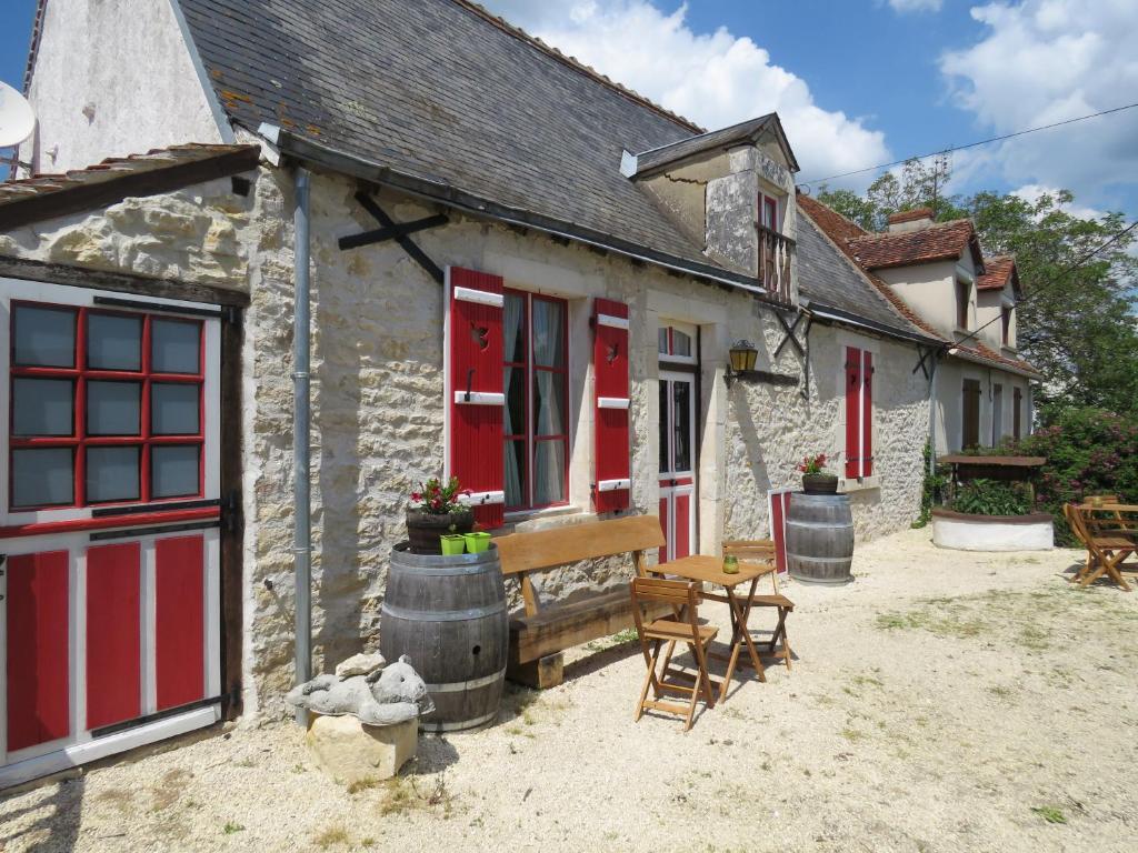 a cottage with red doors and a table and chairs at Lalot in Oulches