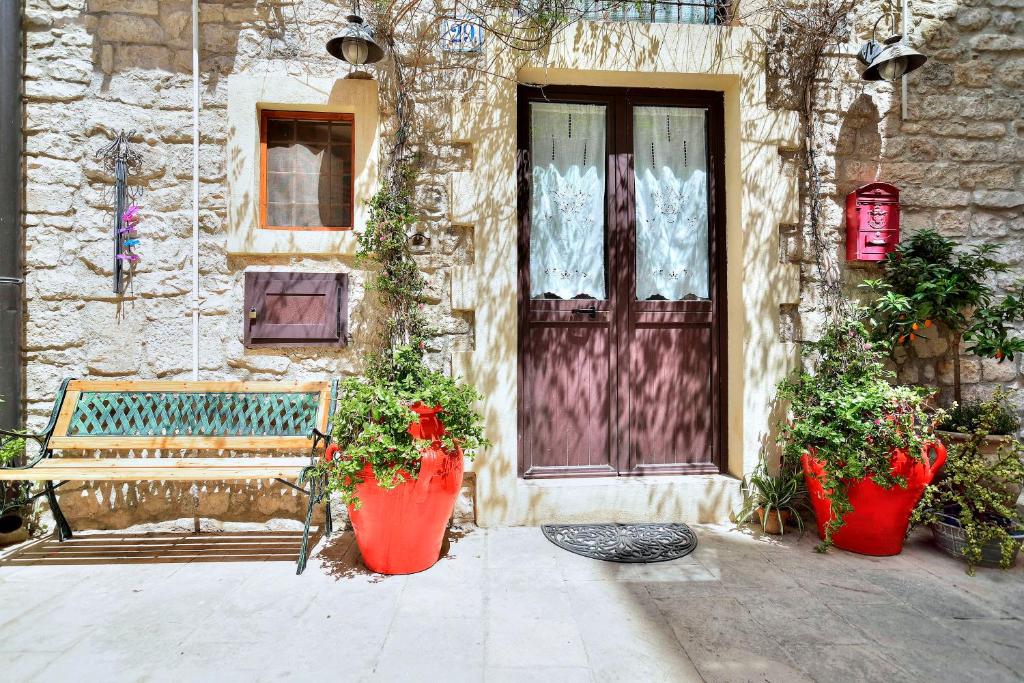 a bench sitting in front of a building with plants at Case del Vicolo Stretto in Modica