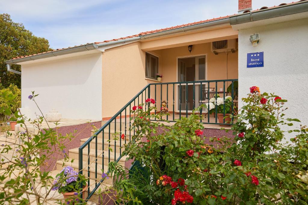 una casa con un balcón con flores delante en Agriculture & Holiday house Lasko, en Goveđari