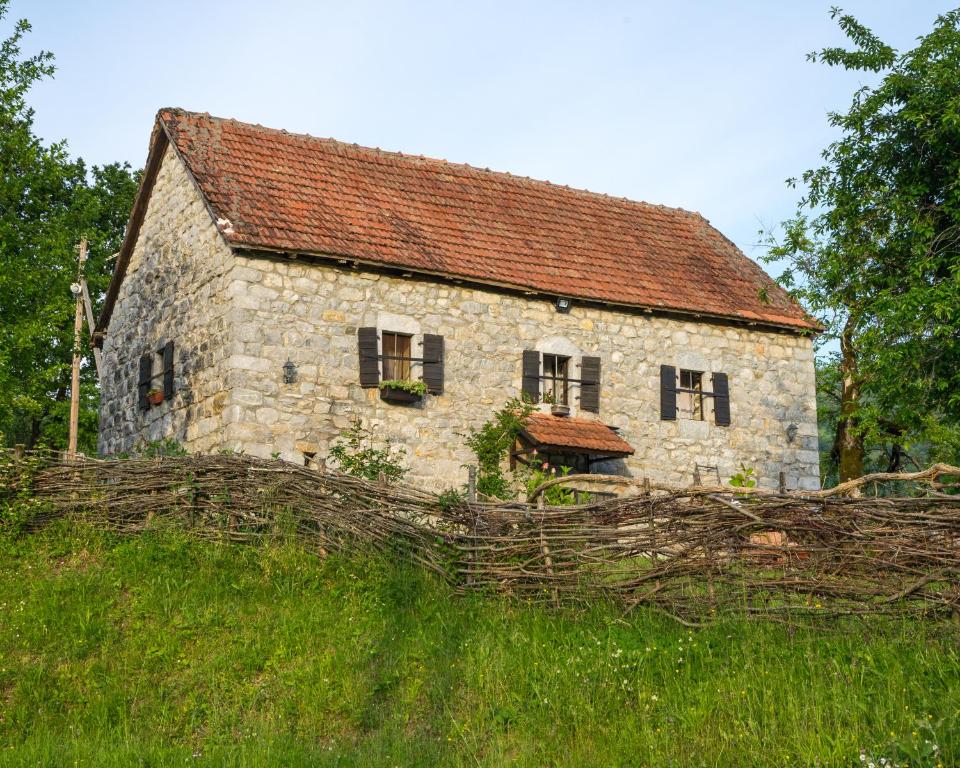 コラシンにあるDjurdjevina Family Farmの草の丘に腰掛けた古い石造りの家