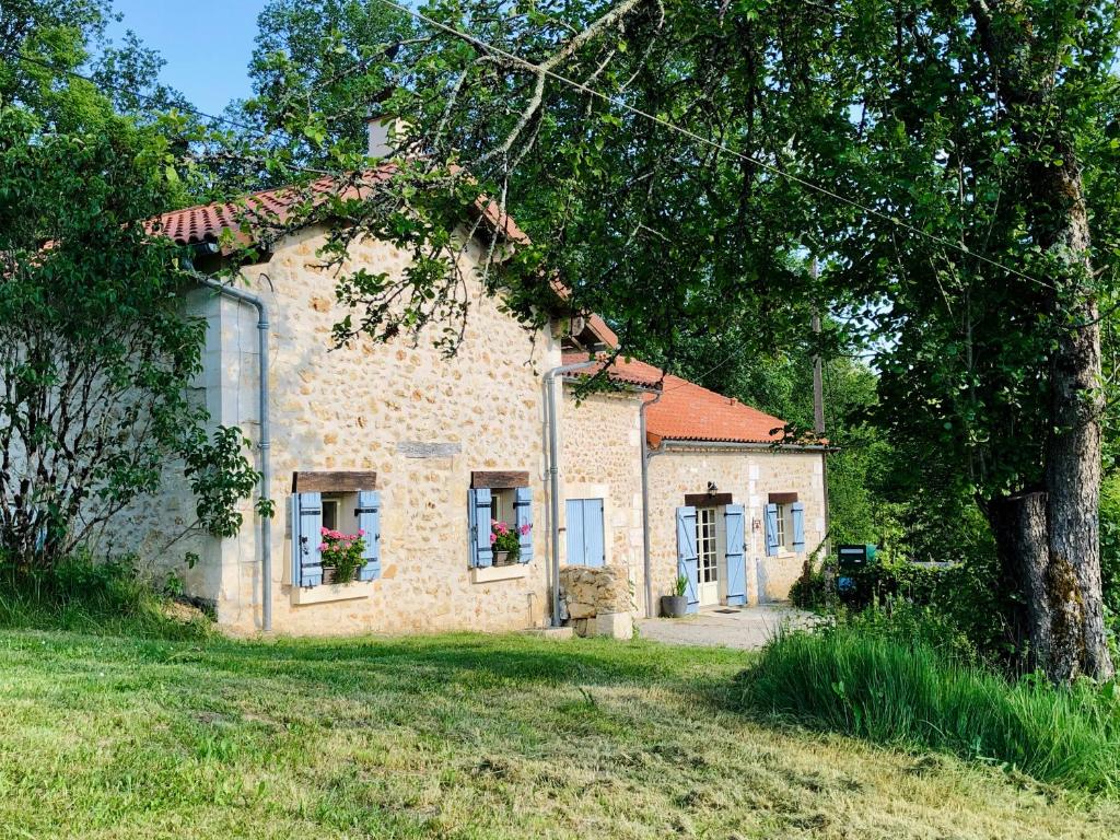 a stone house with flowers in the windows at MaBelle rêve B&B in Saint-Pierre-de-Côle