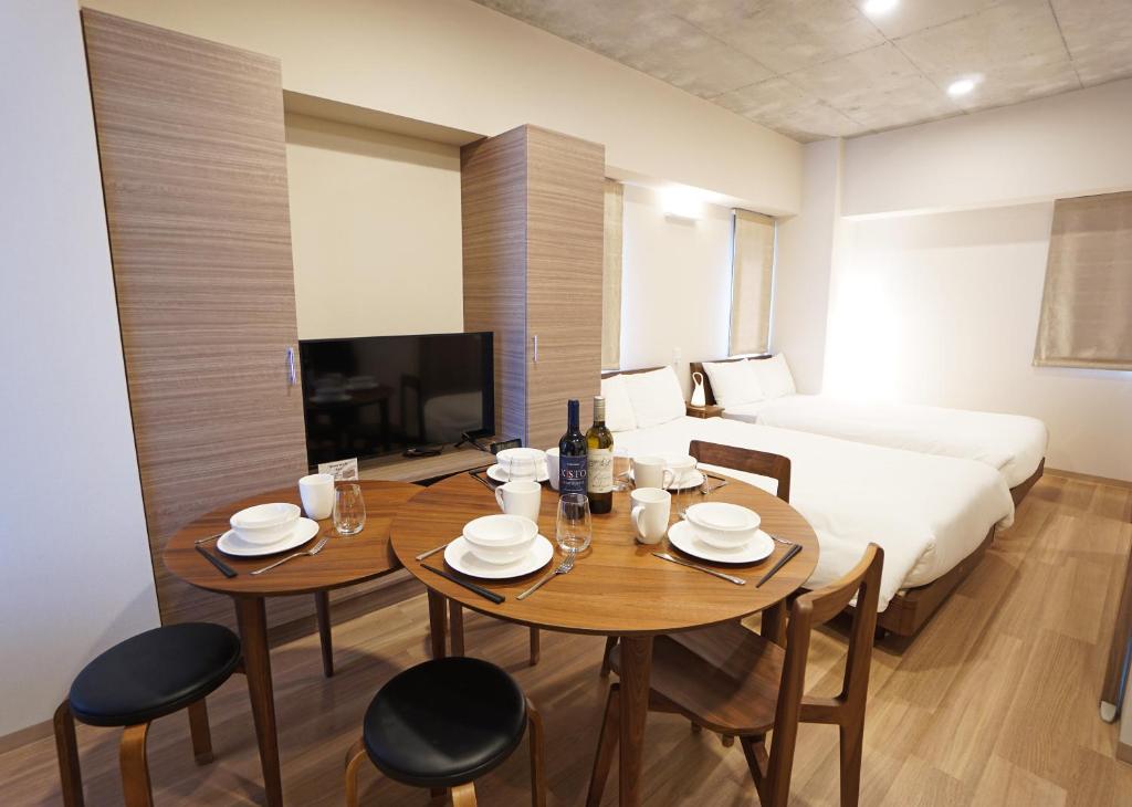 東京にあるPrime Suites Tokyoのテーブル、椅子、ベッドが備わる客室です。