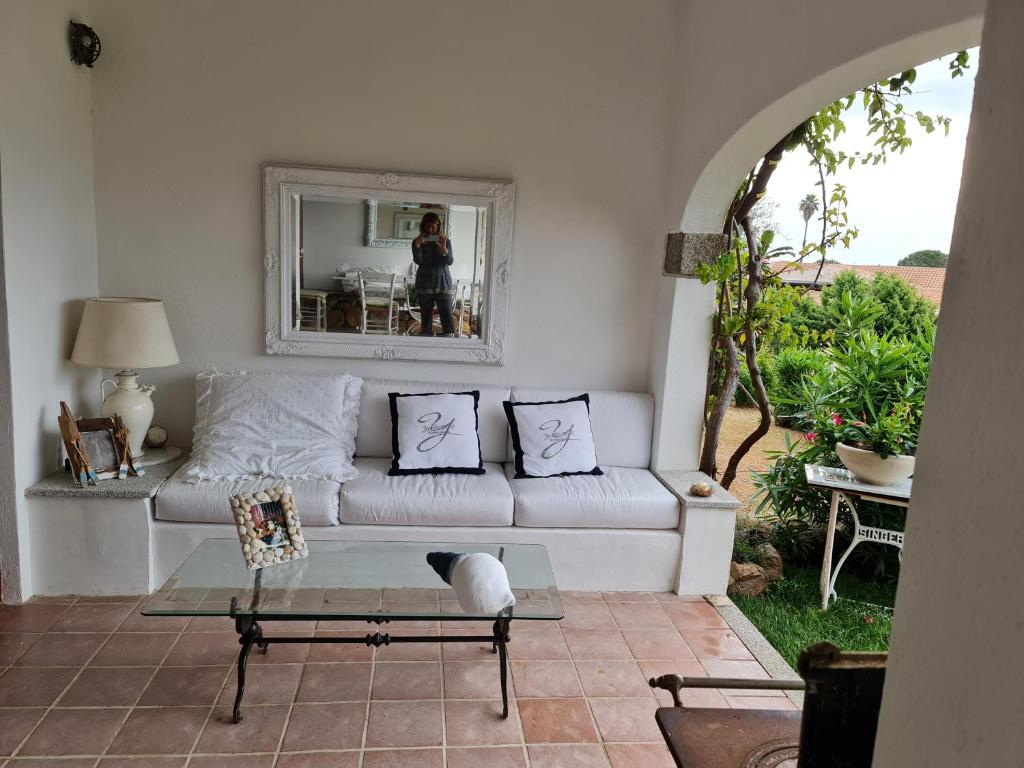 ゴルフォ・アランチにある47 Viale Concas Caddinas Villa Miaのリビングルーム(白いソファ、鏡付)