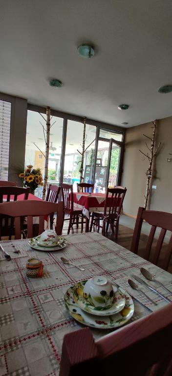 une salle à manger avec une table, des assiettes et des ustensiles de cuisine dans l'établissement Agritur Leita, à Tuenno