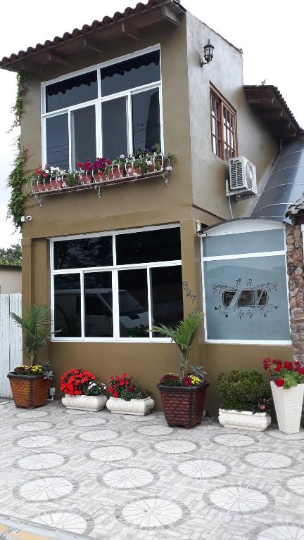 a house with potted plants in front of it at Pousada da Lu em Pelotas in Pelotas