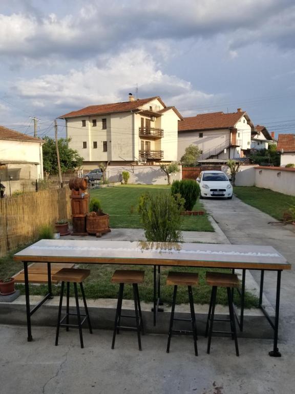 duży stół z dwoma stołkami na dziedzińcu w obiekcie Eftimija Apartments w mieście Gewgelija