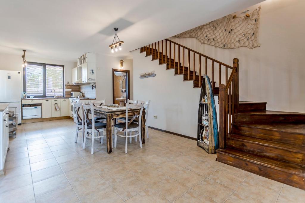 洛澤內茨的住宿－Anistalia - Villa Acacia，厨房以及带桌子和楼梯的用餐室。