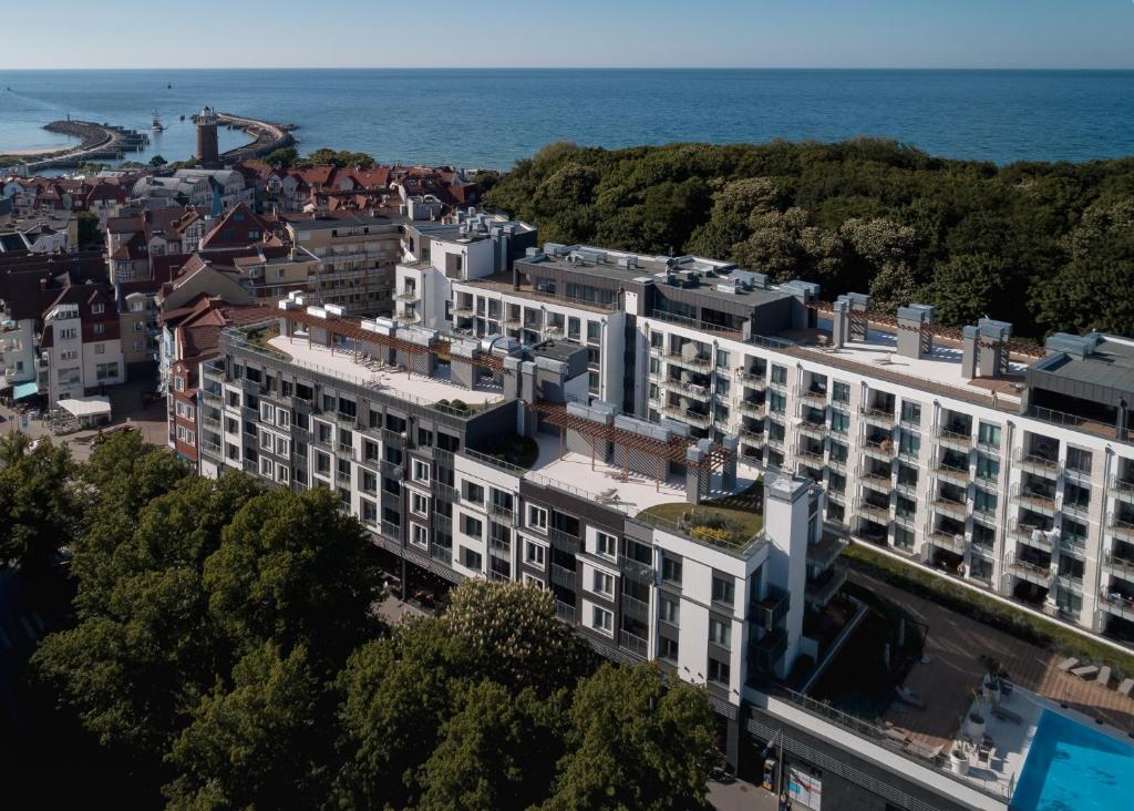 an aerial view of a building with the ocean in the background at Apartamenty Forest - Nadmorskie Tarasy D409 in Kołobrzeg