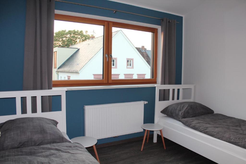 1 dormitorio con 2 camas y ventana en FeWo Krämer, en Plein
