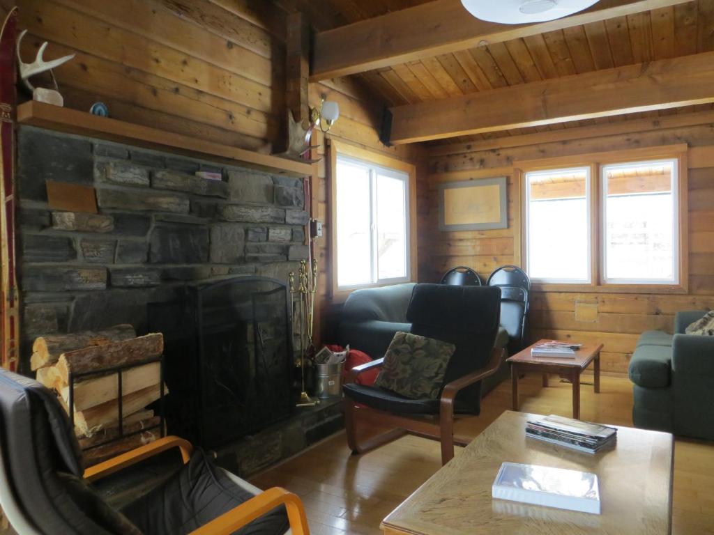 a living room with a fireplace in a log cabin at HI Kananaskis Wilderness - Hostel in Kananaskis Village