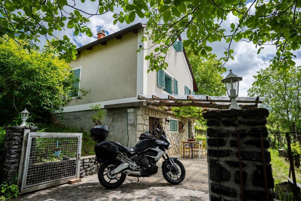 een motorfiets geparkeerd voor een huis bij HillSide Gasthaus 2 a Szent György-hegy lankáin in Tapolca