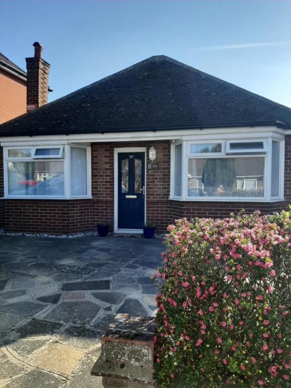 a brick house with a blue door and a bush at Home from Home Stay Margate in Margate