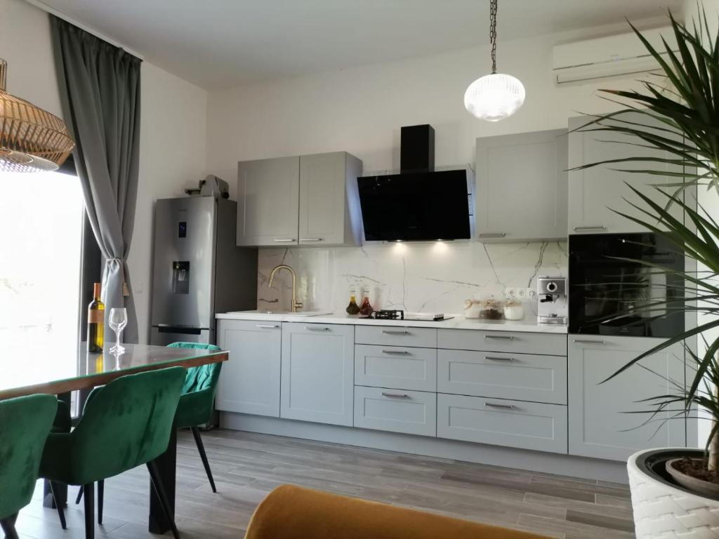 kuchnia z białymi szafkami i stołem w obiekcie Seaview Holiday Apartments, Ventura Nin w Nin