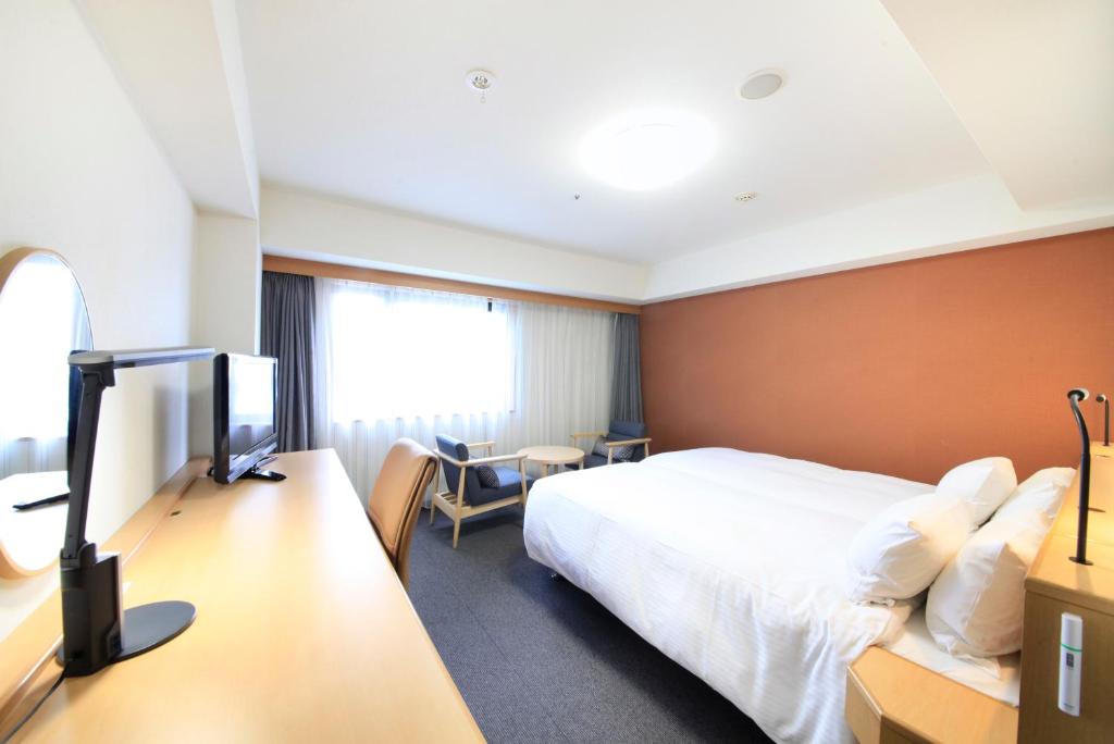 Richmond Hotel Hakata Ekimae في فوكوكا: غرفه فندقيه سرير وتلفزيون