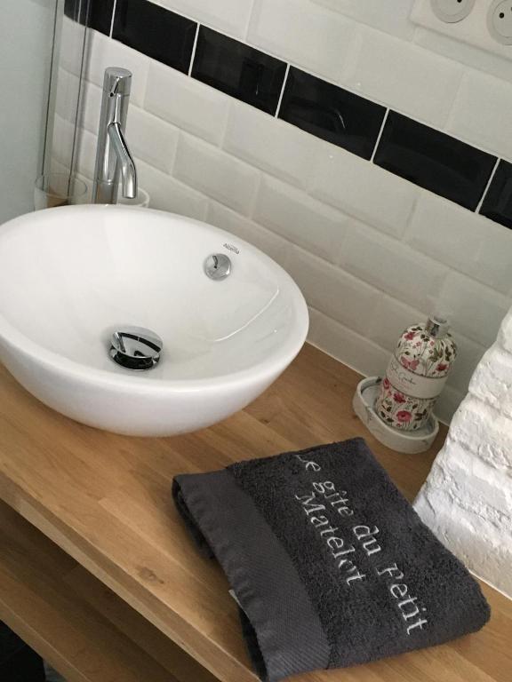 un lavabo blanc sur un comptoir en bois dans une salle de bain dans l'établissement Le gîte du Petit Matelot, à Fécamp