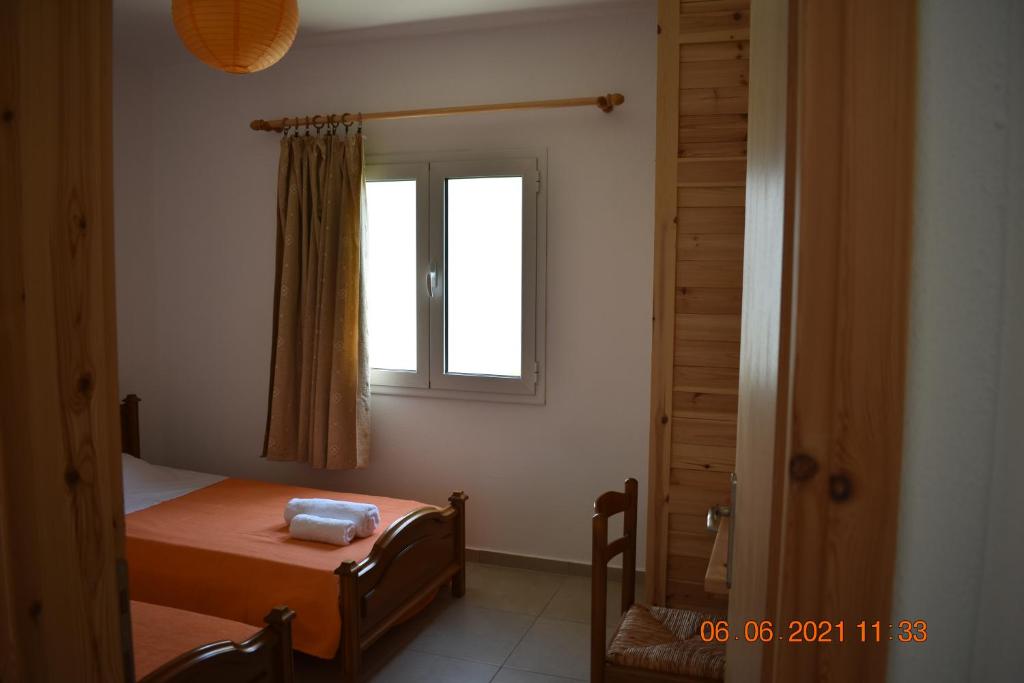 a small bedroom with a bed and a window at Orange Tree Garden in Pefkochori