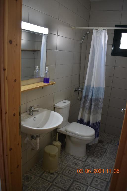 a bathroom with a sink and a toilet and a mirror at Orange Tree Garden in Pefkochori