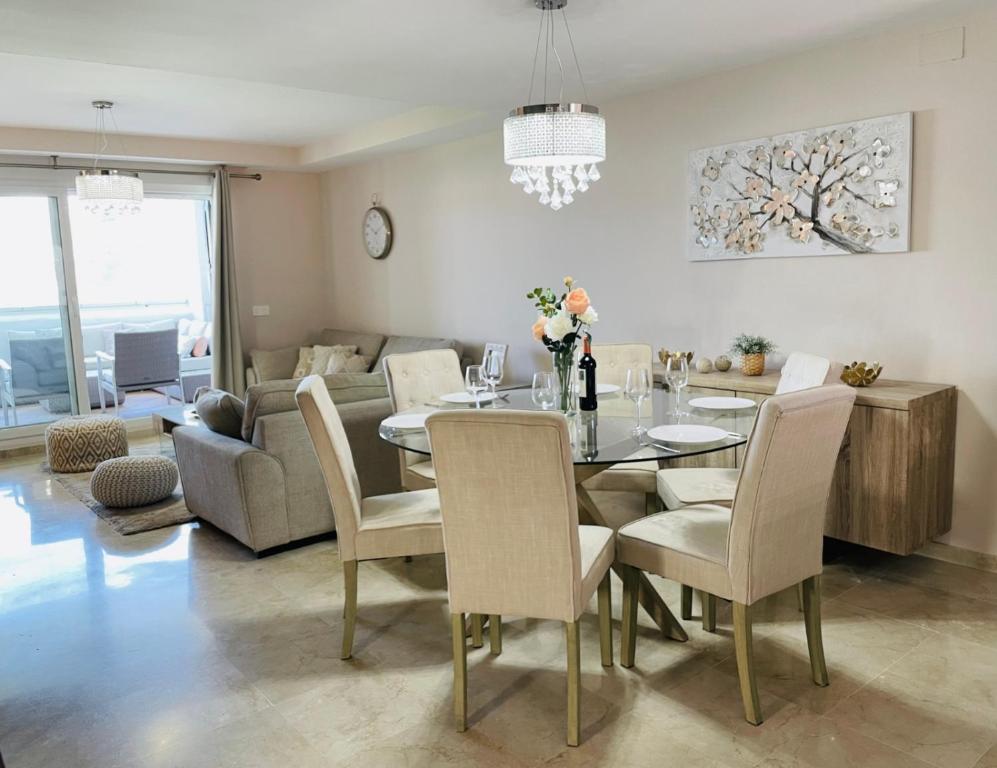 comedor con mesa, sillas y sofá en Royal Cabopino Casa 21, en Marbella