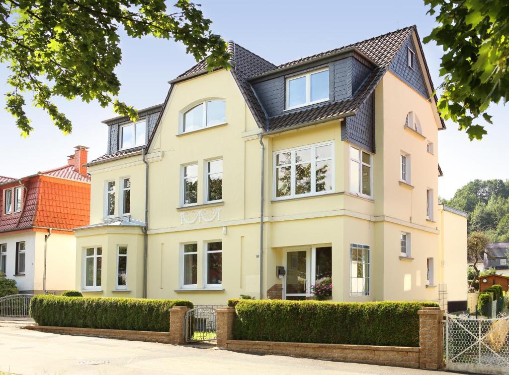 a large yellow house with a black roof at Ferienwohnung Am Schildautal-mit Gartenlounge & WLAN in Seesen