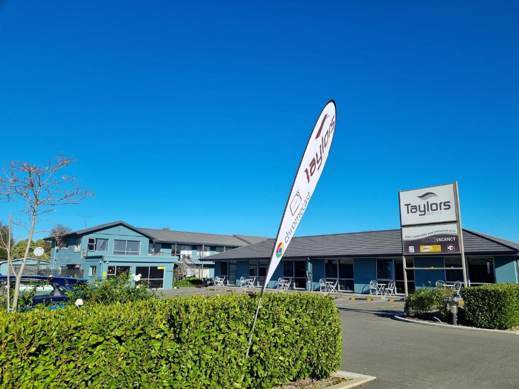 un letrero de la calle frente a un edificio en Taylors Motel, en Ashburton