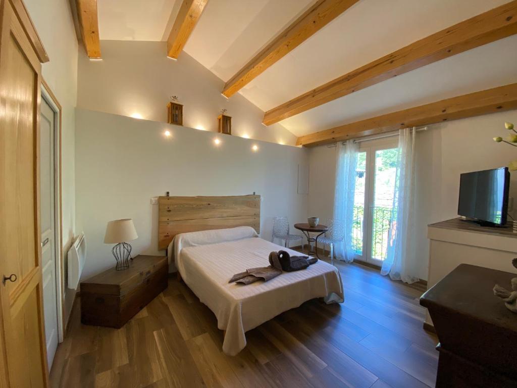 1 dormitorio con 1 cama y TV en A MANDRIA, appartements avec cuisine 30m2, patio, vue Montagnes et citadelle, 5 minutes à pied du centre ville et des rivières, en Corte
