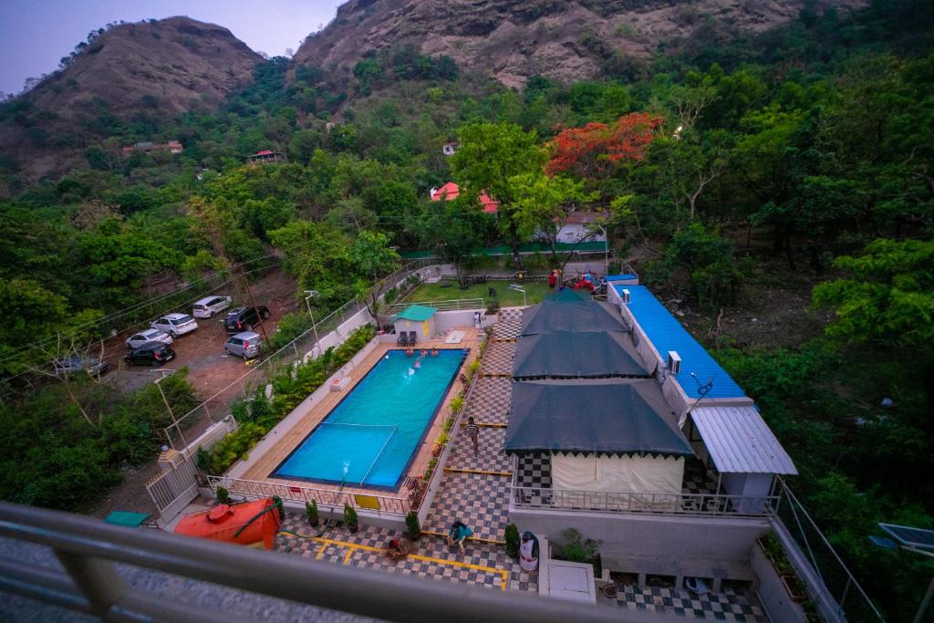 an overhead view of a swimming pool with a mountain at Indradhanush Hill Resort in Mulshi