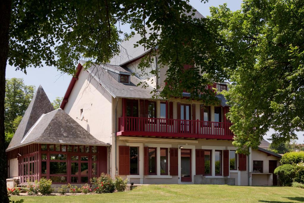 a large white house with a red balcony at Le Monde de Charlie in Vichy