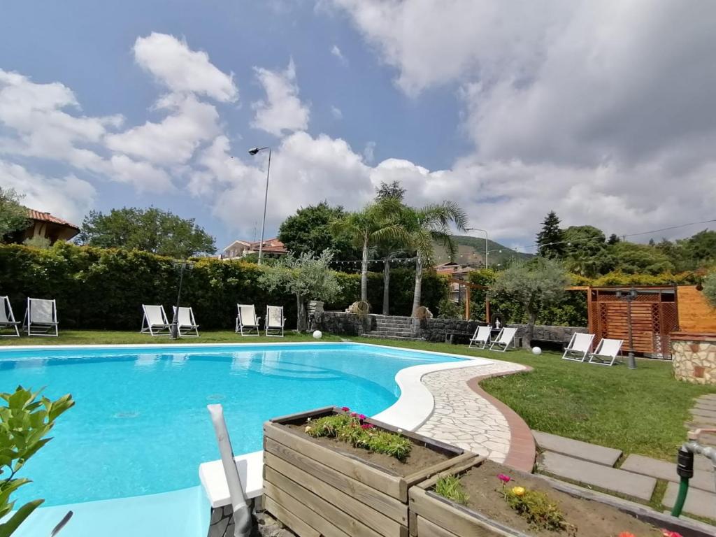 una piscina in un cortile con sedie di Etna Winery a Zafferana Etnea