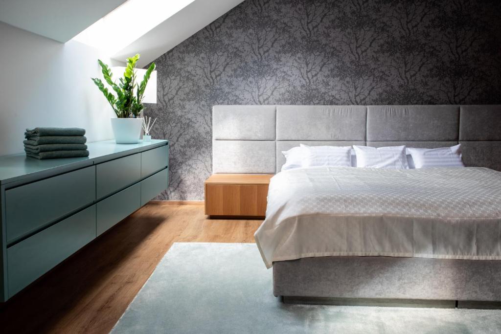 - une chambre avec un lit et une commode avec une plante dans l'établissement ATRIO Apartments, à Trenčín