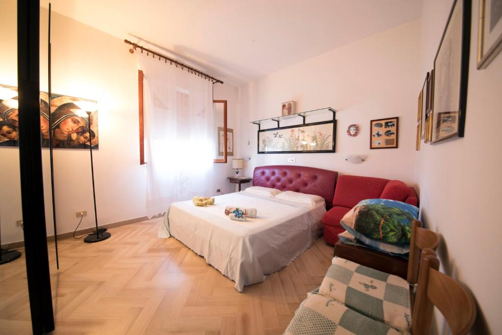 salon z czerwoną kanapą i łóżkiem w obiekcie Casa vacanze Podere Bellavista w mieście Monteprandone
