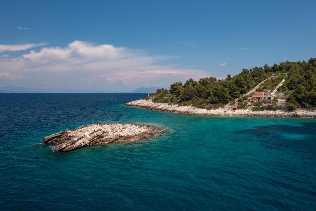 an island in the ocean with a house on it at Villa Insula in Vela Luka