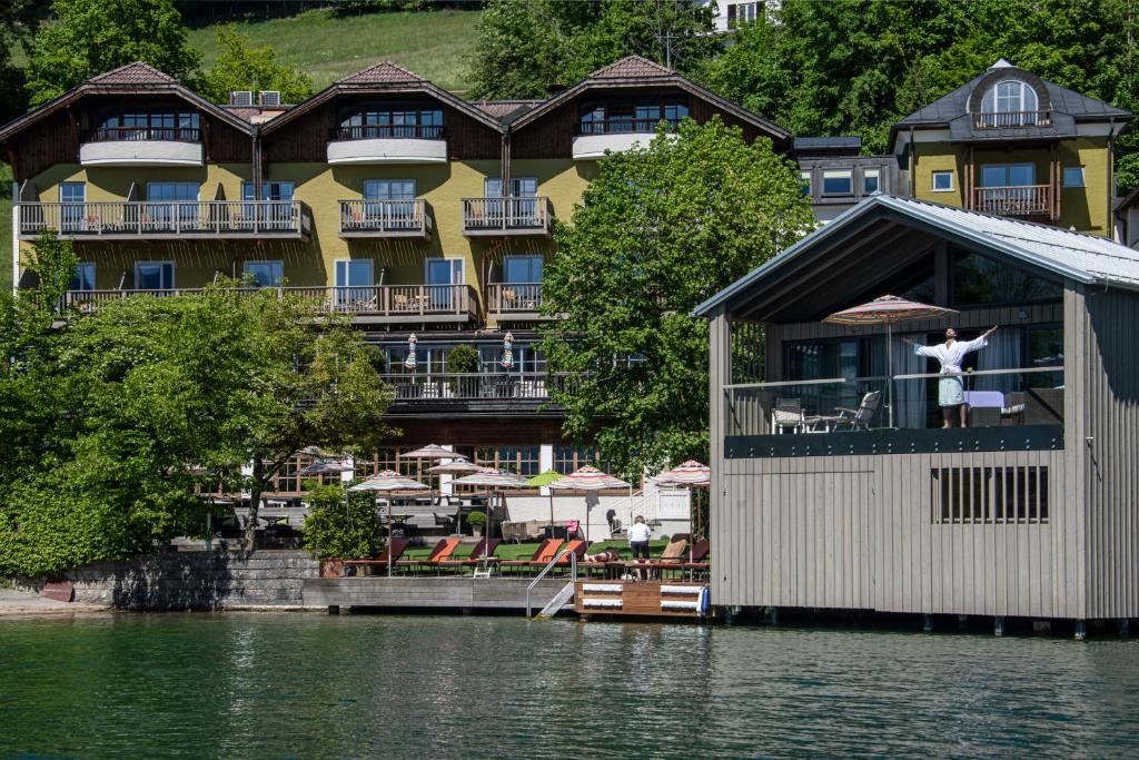 a dog jumping off the balcony of a building on the water at Cortisen am See - Adults only in St. Wolfgang