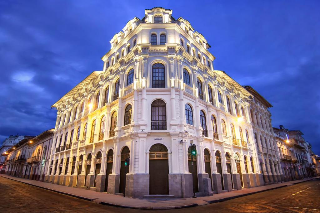 a large white building with lights on it at night at Gran Colombia Suites in Cuenca