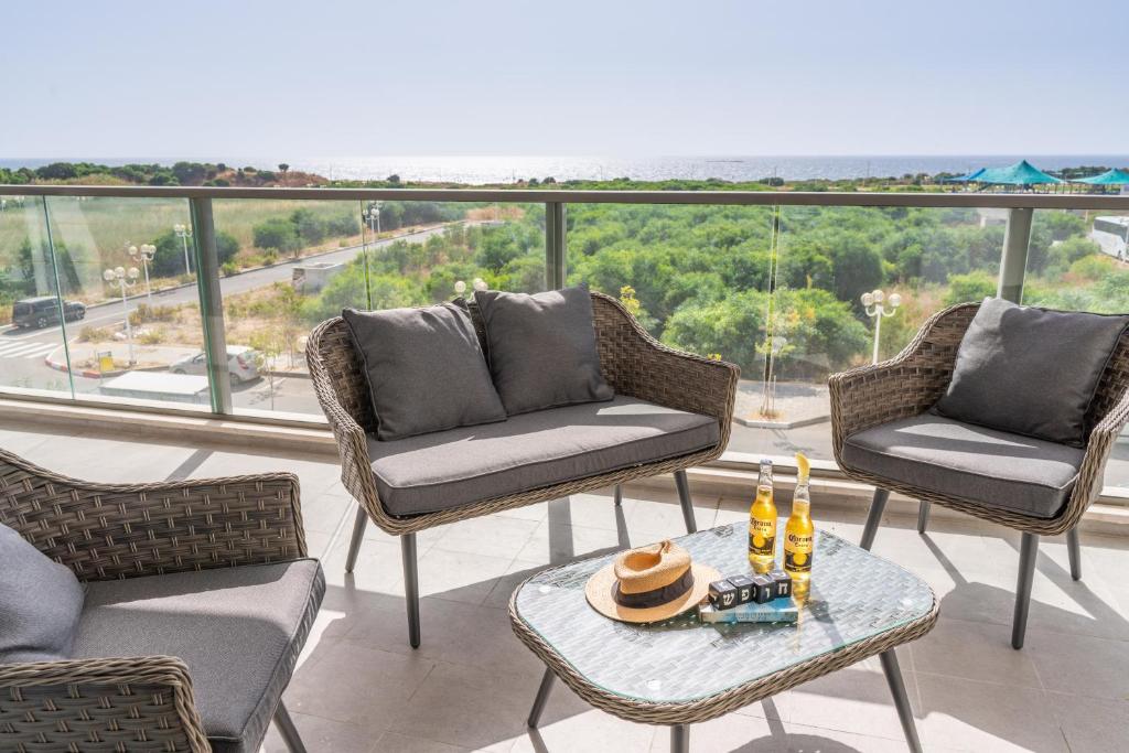 a balcony with chairs and a table with drinks on it at Stunning 4-bedroom Apartment Next to Achziv Beach by Sea N' Rent in Nahariyya
