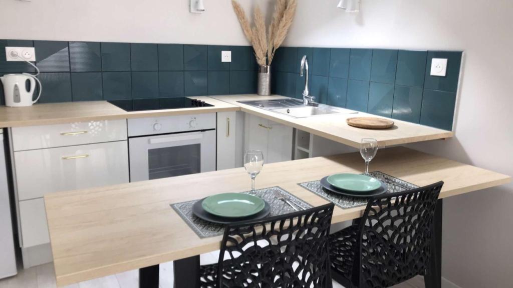 a kitchen with a wooden table with two green plates on it at Studio ,Centre Historique , Entrée Autonome in Montélimar