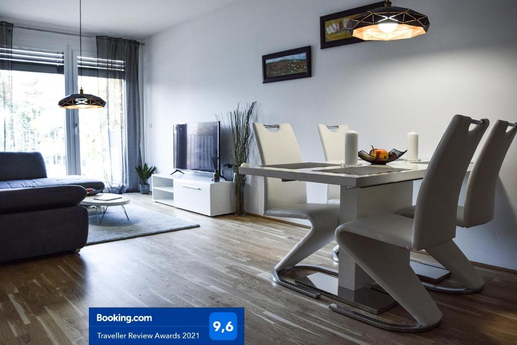 uma sala de estar com uma mesa branca e cadeiras em Cosy new Apartment 3min to VIC/Uno-City and Danube em Viena