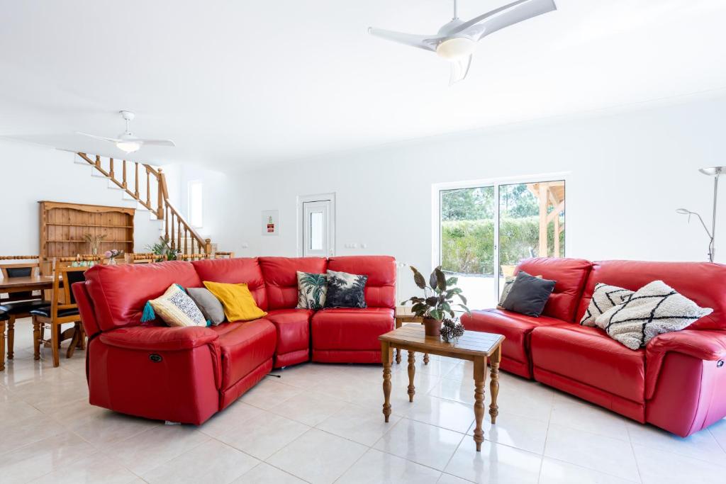 a red couch in a living room with a table at Villa Flavia in Aljezur