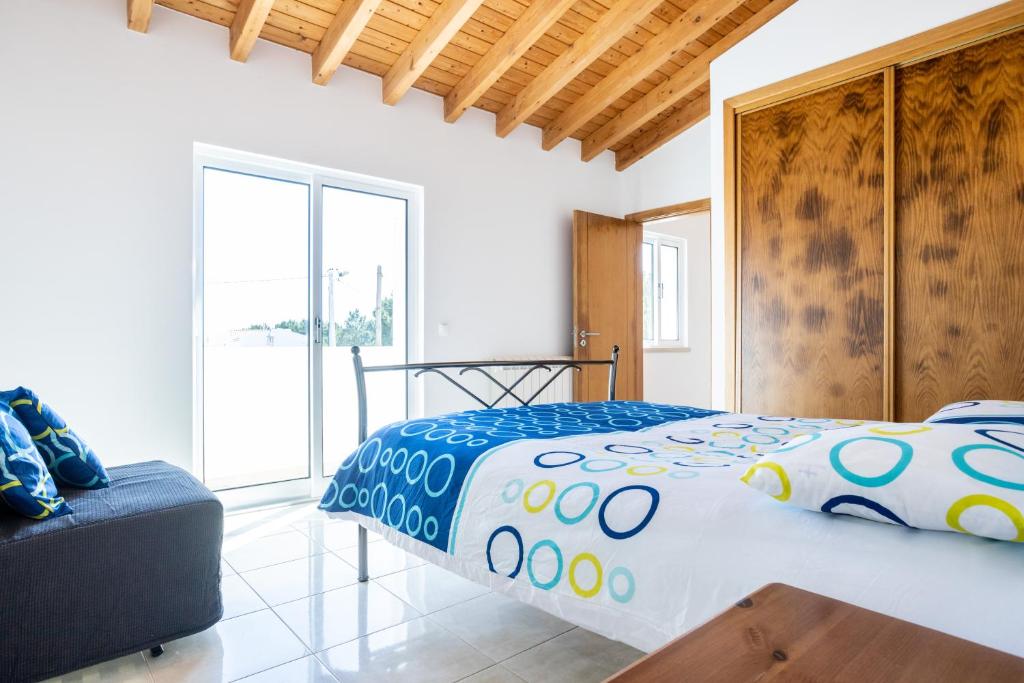 a bedroom with a large bed and a couch at Villa Flavia in Aljezur