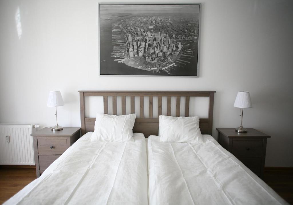 a bedroom with a large bed with white sheets and pillows at Apartament Manhattan in Kołobrzeg