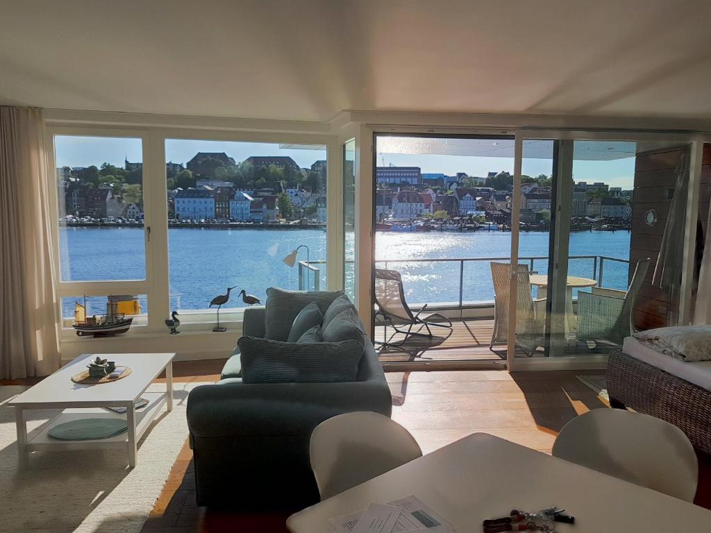 a living room with a view of the water at Loft 5 - Urlaub direkt an der Förde in Flensburg