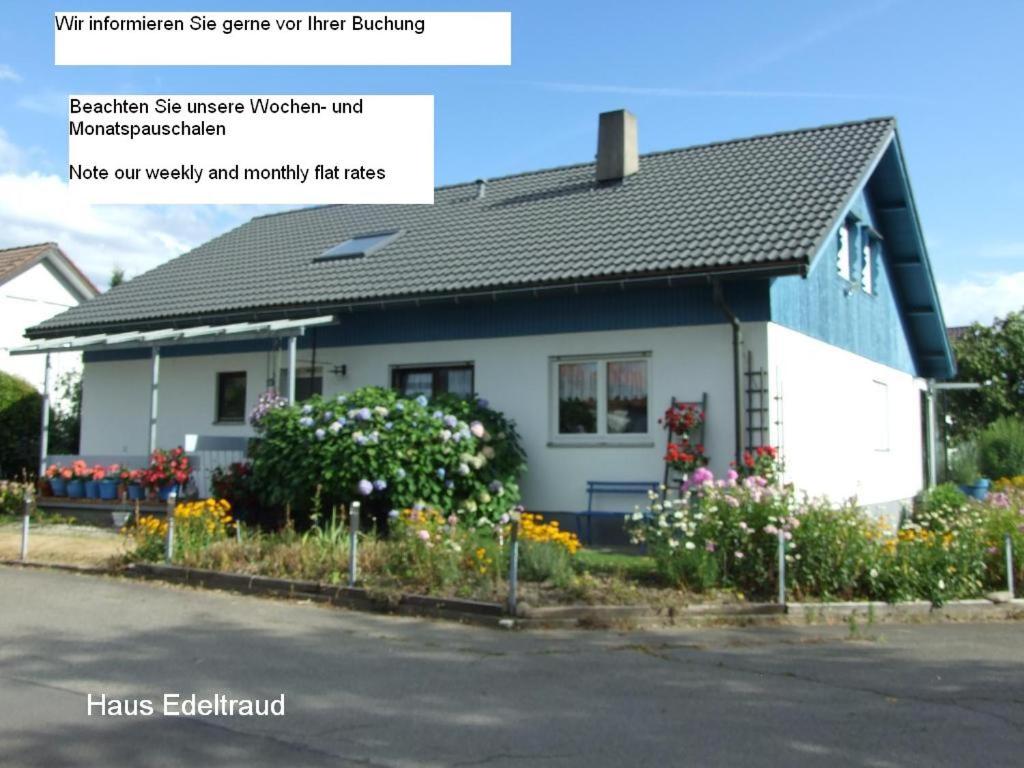 uma casa branca com flores à frente em Ferienwohnung Haus Edeltraud im Südschwarzwald, grosse, helle, ruhige Souterrain-Whg, Hunde geeignet, mit 2 Fahrrädern, 3 Bäckereien mit Frühstück, 2 Lebensmittel-, 1 Italien-Pastaläden, Kontakt Peter Heubüschl aus Lörrach em Rheinfelden