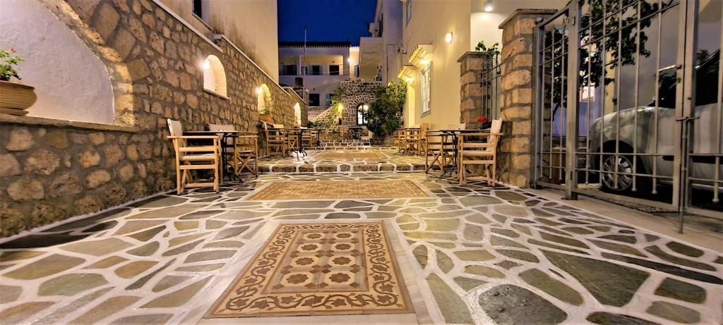 a room with a tile floor with a table and chairs at Kastro Hotel in Spetses
