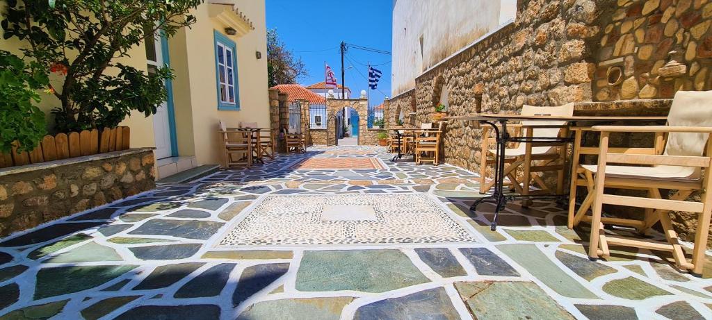 a stone walkway with tables and chairs on a street at Kastro Hotel in Spetses