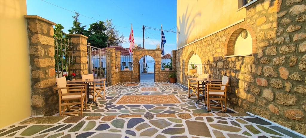 a patio with tables and chairs in a building at Kastro Hotel in Spetses