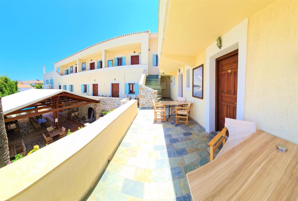 a balcony of a building with a table and chairs at Kastro Hotel in Spetses