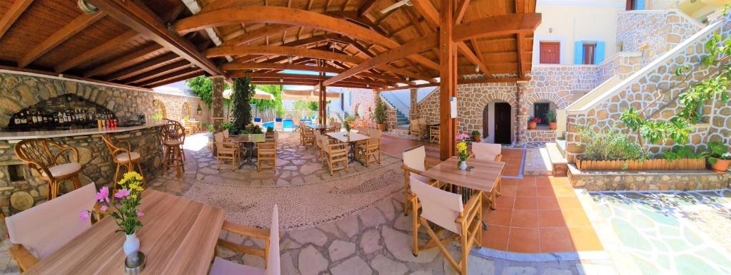 a restaurant with tables and chairs and a pool at Kastro Hotel in Spetses