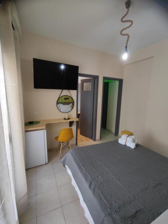 a bedroom with a bed and a tv on the wall at Poseidon Rooms in Kala Nera