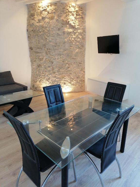 une table et des chaises en verre dans une chambre avec télévision dans l'établissement Au Thiernois, à Thiers