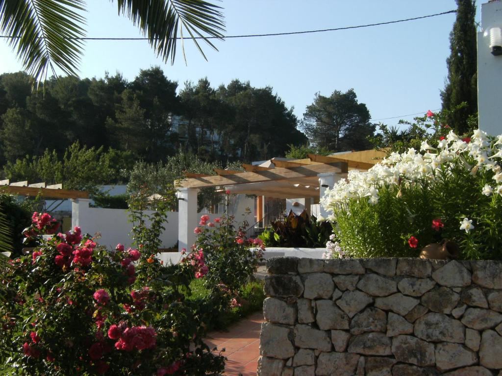a garden with flowers and a stone wall at Hotel Rural Can Maries in Puerto de San Miguel