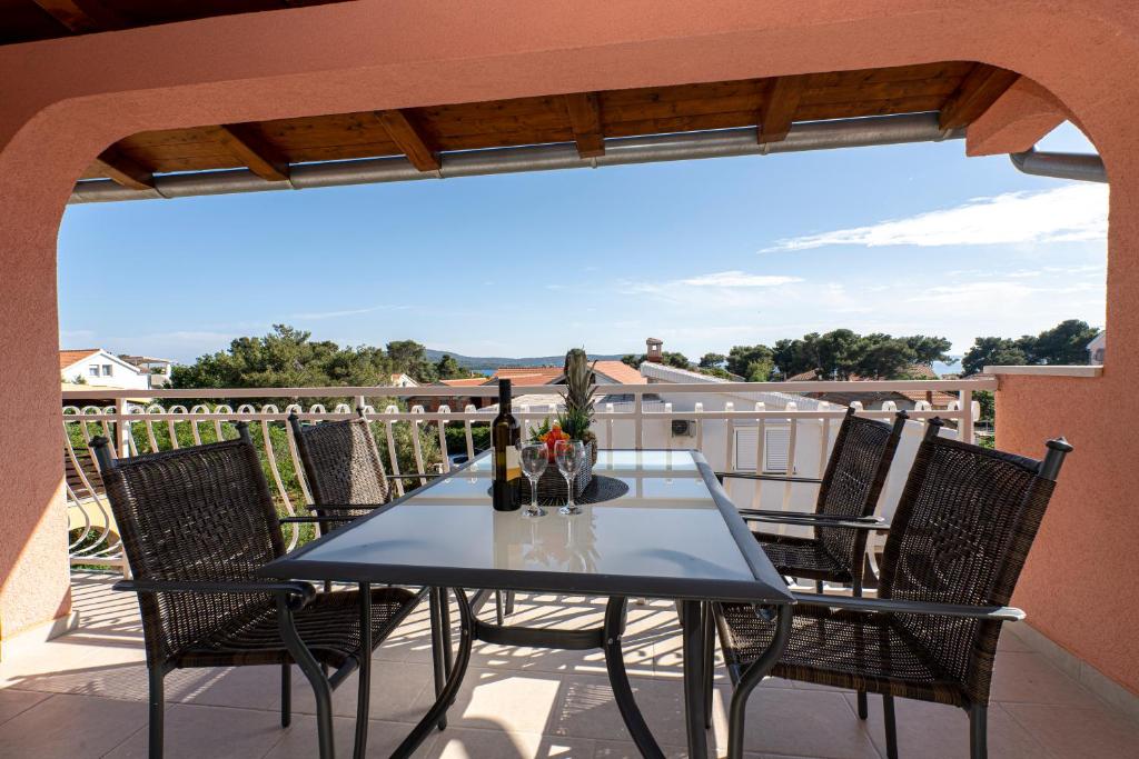 uma mesa e cadeiras numa varanda com vista em Seaview & Balcony Apartment PETRA I em Jadrija